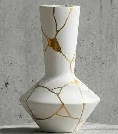 A white vase with its cracks mended in gold, the Japanese art of kintsugi
