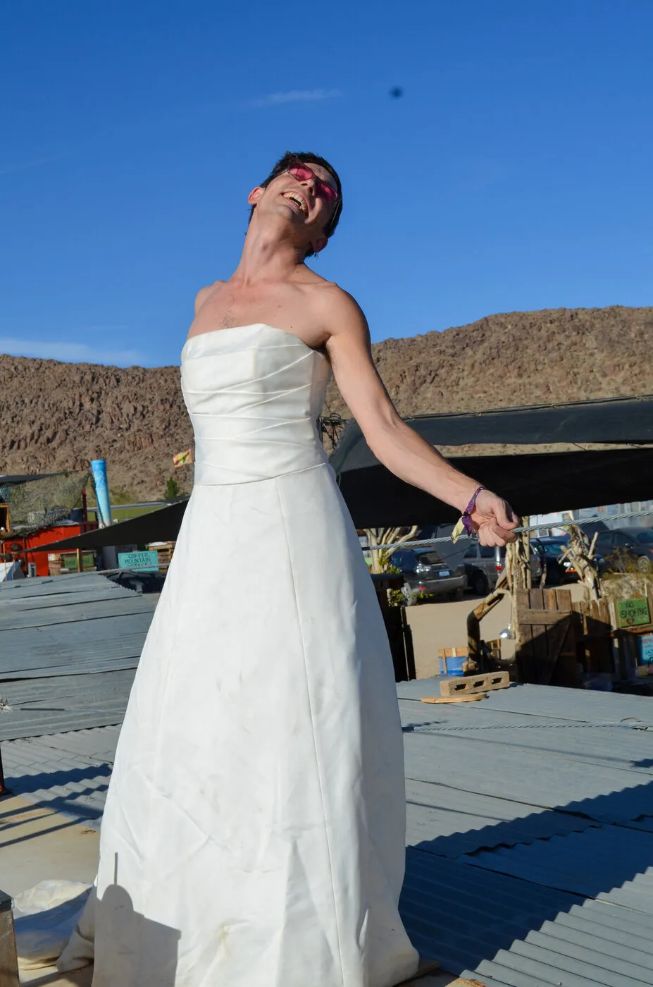 A woman in The Divorce Dress tipping her head back to the blue desert sky